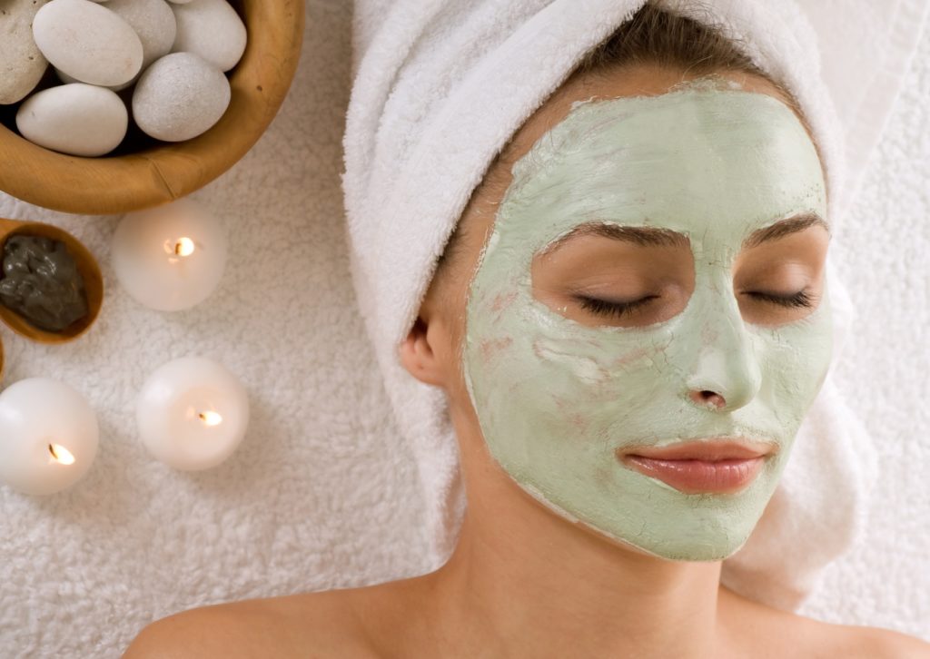 Femme avec un masque d'argile verte sur le visage